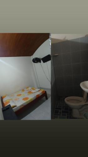 uma pequena casa de banho com uma cama e um WC em Establecimiento luz y fer em San Vicente del CaguÃ¡n