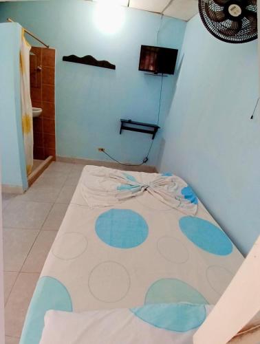 Cama en habitación con pared azul en Establecimiento luz y fer, en San Vicente del CaguÃ¡n