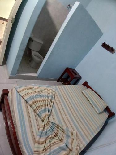 uma cama num quarto com uma escada em Establecimiento luz y fer em San Vicente del CaguÃ¡n