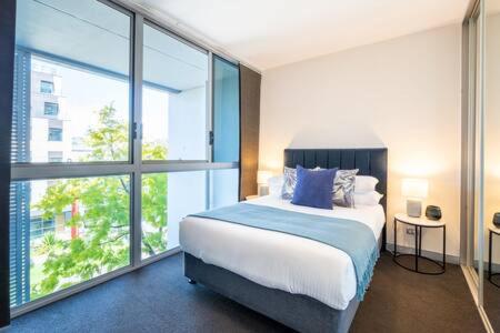 a bedroom with a bed and a large window at Sleek Inner-City Getaway in Prime Location in Sydney