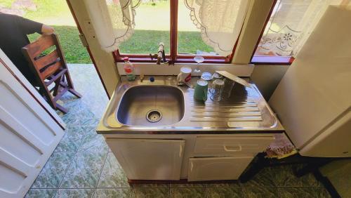 ein kleines Waschbecken in einem kleinen Zimmer mit Fenster in der Unterkunft Hospedajes Richie Eco Camp in Providencia