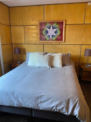 a bedroom with a white bed with two lamps at Acogedora casa céntrica en Panguipulli in Panguipulli