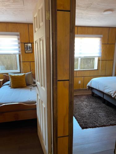 a bedroom with a bed and two windows and a door at Acogedora casa céntrica en Panguipulli in Panguipulli