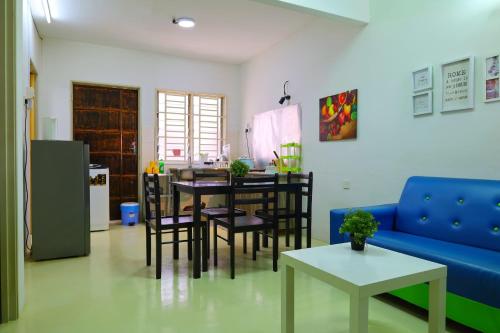 sala de estar con sofá azul, mesa y sillas en Adno Homestay Seroja#3BR#5 Single#IKEA#High Speed Wifi#5pax, en Simpang Ampat