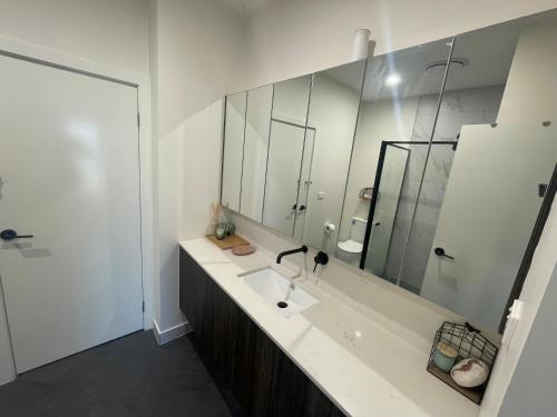 a bathroom with a sink and a large mirror at Funstay in Cheltenham