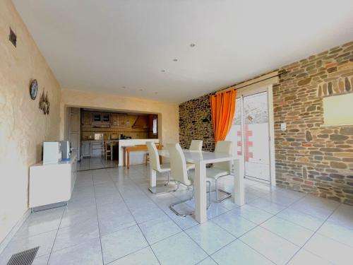 d'une salle à manger avec une table, des chaises et un mur en briques. dans l'établissement Villa F5 à Banyuls-sur-Mer: Terrasse, Garage, Clim, Proche Mer - FR-1-309-149, à Banyuls-sur-Mer