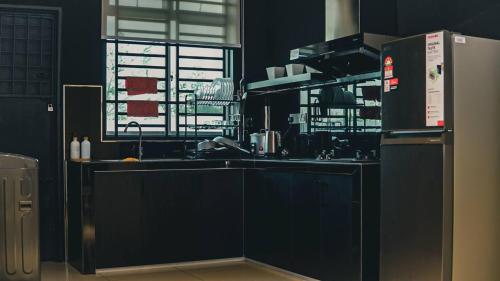 a kitchen with a sink and a refrigerator at Calma Villa @ Pendang in Pendang