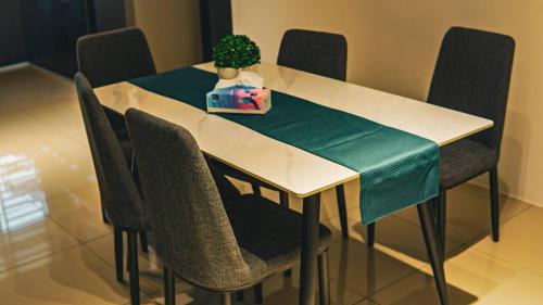 a white table with chairs and a potted plant on it at Calma Villa @ Pendang in Pendang