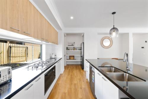 a kitchen with white counters and a wooden floor at Paterson Retreat in San Remo