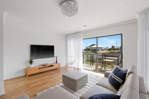 a living room with a couch and a flat screen tv at Paterson Retreat in San Remo
