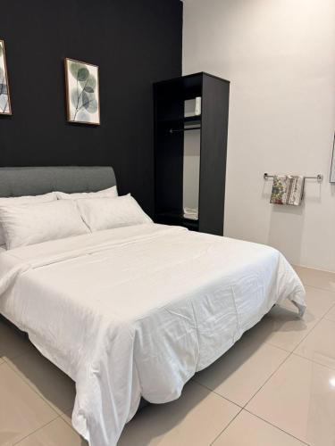a large white bed in a bedroom with a black wall at Calma Villa @ Pendang in Pendang