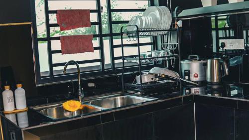 encimera de cocina con fregadero y ventana en Calma Villa @ Pendang, en Pendang