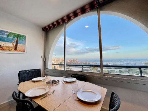 une salle à manger avec une table et une grande fenêtre dans l'établissement Charmant T2 avec garage proche plage à Sète, animaux acceptés - FR-1-338-437, à Sète