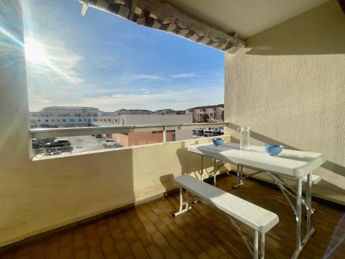 un balcon avec une table et une vue sur une ville dans l'établissement 2 pièces cabine proche des plages, parking, clim - FR-1-338-487, à Sète