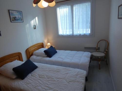 une chambre avec deux lits et une fenêtre dans l'établissement Notre-Dame-de-Monts - Appart 2 ch. vue océan, 6 pers., animaux admis, parking - FR-1-540-240, à Notre-Dame-de-Monts