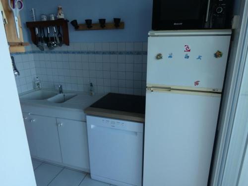 une cuisine avec un réfrigérateur blanc et un évier dans l'établissement Notre-Dame-de-Monts - Appart 2 ch. vue océan, 6 pers., animaux admis, parking - FR-1-540-240, à Notre-Dame-de-Monts
