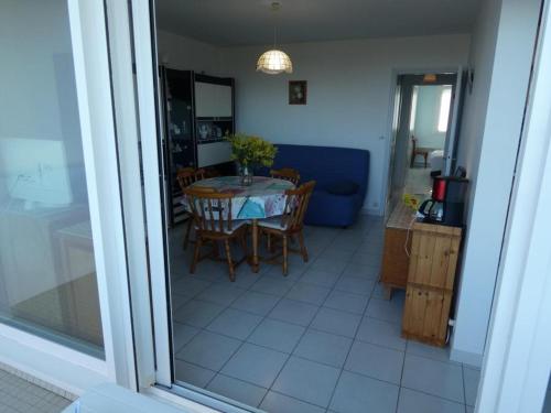 une cuisine et une salle à manger avec une table et des chaises dans l'établissement Notre-Dame-de-Monts - Appart 2 ch. vue océan, 6 pers., animaux admis, parking - FR-1-540-240, à Notre-Dame-de-Monts