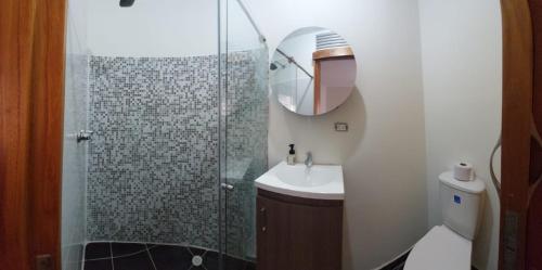 a bathroom with a shower and a sink and a mirror at Casa Palermo Manizales in Manizales