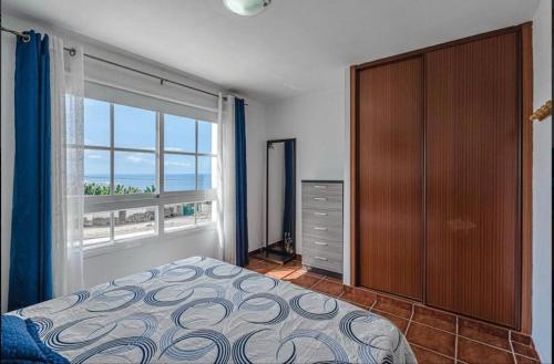een slaapkamer met een bed en een groot raam bij Comfy Duplex For Family Vacations in Callao Salvaje