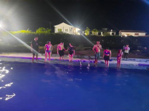 a group of people standing in the water at night at Casa Quinta la excelencia in Melgar