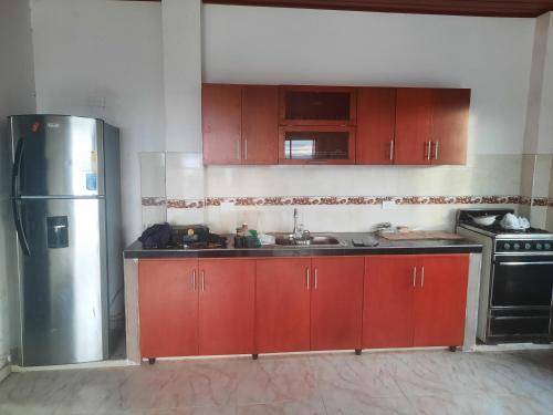 a kitchen with red cabinets and a stainless steel refrigerator at Casa Quinta la excelencia in Melgar