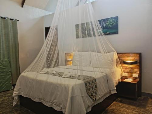 EPBliss Villas Resort Siargao في جنرال لونا: غرفة نوم بسرير مع ناموسية