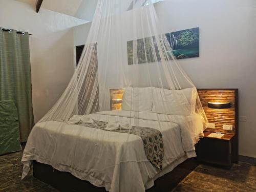 a bedroom with a bed with a mosquito net at Siargao Longterm Villas - EPBliss in General Luna