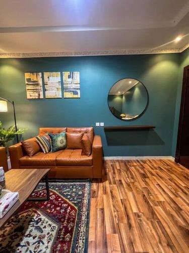 ein Wohnzimmer mit einem Sofa und einem Spiegel in der Unterkunft استديو بتصميم كلاسيكي أنيق ودخول ذاتي in Riad