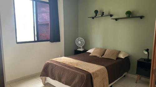 a bedroom with a bed and a window and a fan at Studio Garden 01 Quartos in Caruaru