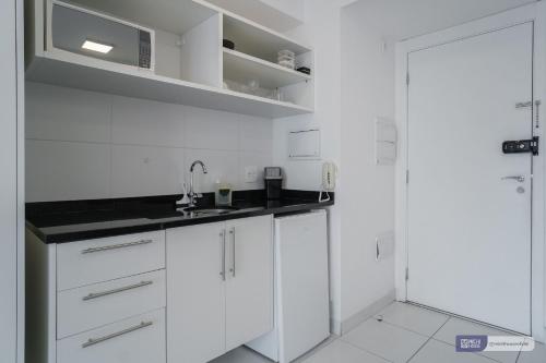 una cocina blanca con armarios blancos y fregadero en MH 50506 - Encantador Studio Expo CN Wi-FI/AC/VG, en São Paulo