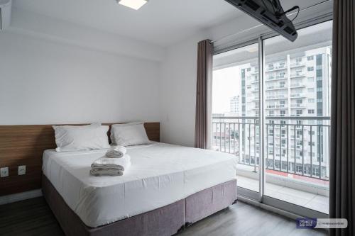 1 dormitorio con cama grande y ventana grande en MH 50506 - Encantador Studio Expo CN Wi-FI/AC/VG, en São Paulo