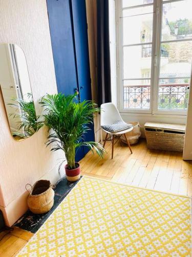 une chambre avec deux plantes en pot au sol dans l'établissement Beautiful bright flat Jardin des Plantes, à Paris