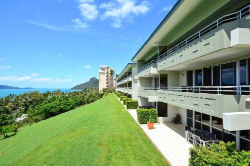 an exterior view of a building with a green lawn at Poinciana 105 in Hamilton Island