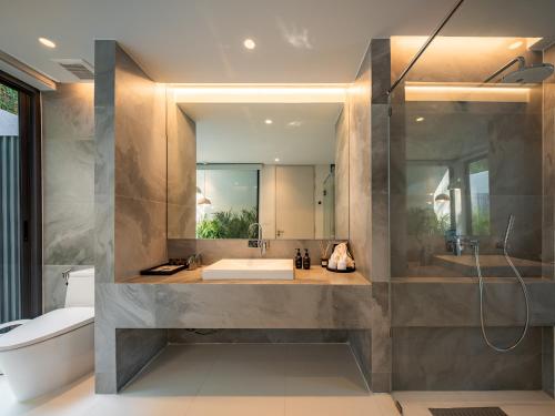 uma casa de banho com uma banheira e um espelho grande em Rhy.a Private Pool Villa em Ko Larn
