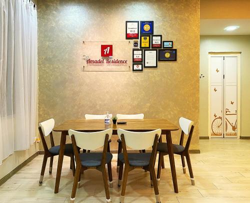 uma sala de jantar com uma mesa de madeira e cadeiras em Amadel Residence 爱媄德民宿 14 em Malaca