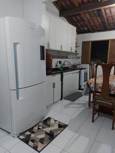 uma cozinha com um frigorífico, uma mesa e cadeiras em Suíte com ar condicionado próximo ao Estádio Mangueirão em Belém