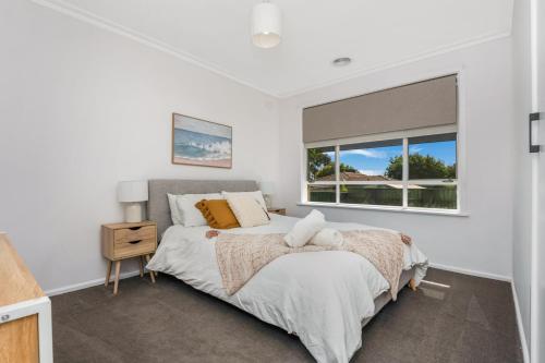 um quarto com uma cama e uma janela em Charming 3BR Home in Bendigo em Kennington