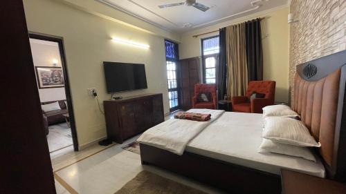 1 dormitorio con 1 cama y TV de pantalla plana en Aarohan Cottage By Ganga Kripa en Rishīkesh
