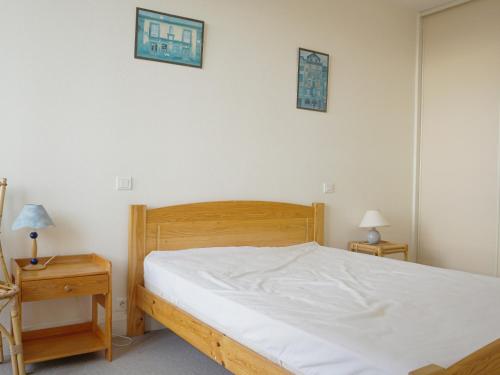 - une chambre avec un lit blanc et 2 tables de chevet dans l'établissement Appartement 2 Chambres Face Mer à Saint-Jean-de-Monts, Entre Casino et Palais des Congrès - FR-1-323-337, à Saint-Jean-de-Monts