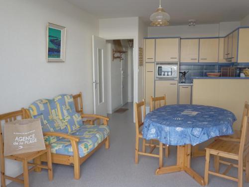 un salon avec une table et des chaises et une cuisine dans l'établissement Appartement 2 Chambres Face Mer à Saint-Jean-de-Monts, Entre Casino et Palais des Congrès - FR-1-323-337, à Saint-Jean-de-Monts