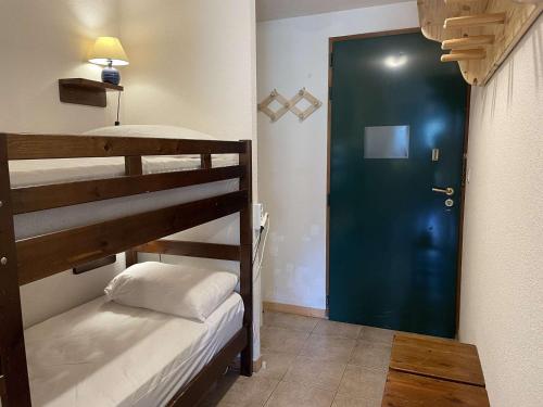 Cette chambre comprend 2 lits superposés et une porte bleue. dans l'établissement Charmant 2P avec terrasse Sud, proche pistes - Montgenèvre - FR-1-330D-138, à Montgenèvre