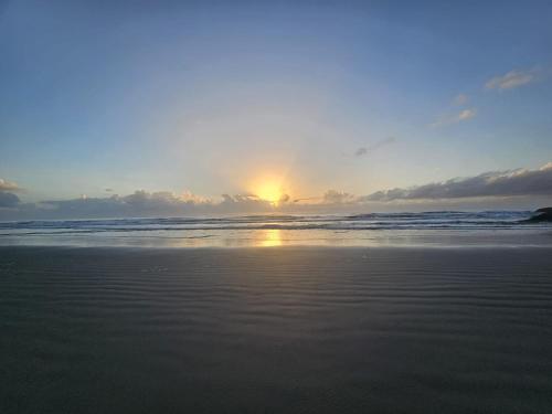 a sunset on a beach with the ocean at Chalé lawill ilha do mel in Paranaguá