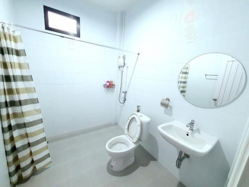 ein Badezimmer mit einem WC, einem Waschbecken und einem Spiegel in der Unterkunft Chalicha pool villa phatthalung in Khuan Khanun