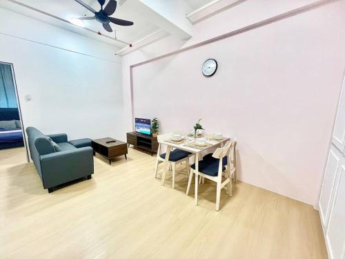 a living room with a table and a couch and a clock at G7 1-8Pax Sunway Medical Center 2Room Geo Avenue in Kampong Penaga