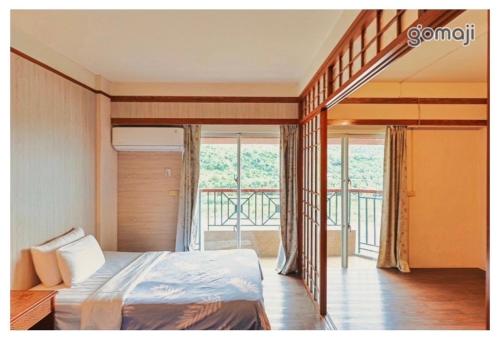溫泉村的住宿－知本富爺飯店Chihpen Fuye Hotel，一间卧室设有一张床和一个阳台