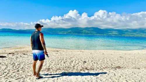 a man standing on a beach looking at the water at Tabskie’s Homestay in Catarman