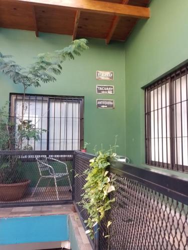 un edificio verde con un banco y carteles en la pared en Bonpland departamentos en Puerto Iguazú