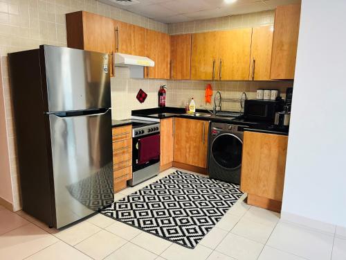 ドバイにあるAmazing 1 bedroom apt in Marinaのキッチン(ステンレス製の冷蔵庫、食器洗い機付)