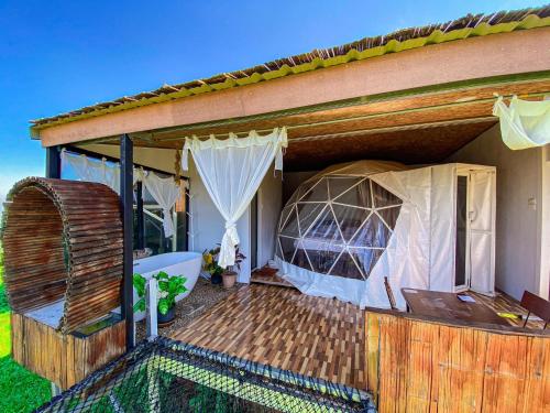 a house with a deck with a tent at ไร่ดอยช้าง ม่อนเเจ่ม in Mon Jam