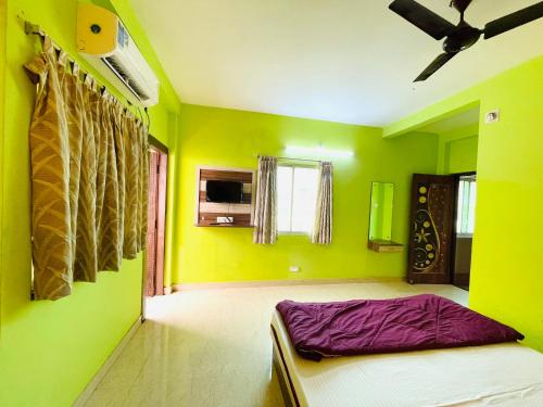 - une chambre avec des murs verts et un lit dans l'établissement Hotel Falcon House ! Puri, à Purî